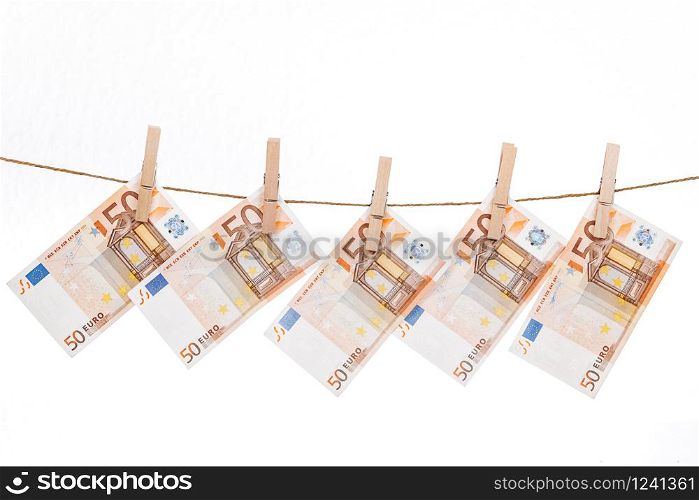 Euro banknotes attached with wooden clothespins to a rope on a white background