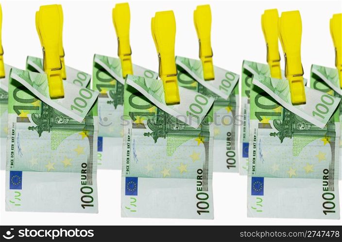 euro banknotes hanging on clothespins on white background