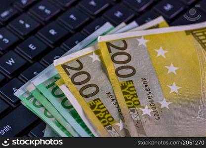 Euro banknotes on keyboard. Selective focus on stack euro money.