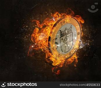 Euro coin burning in fire. Five euro coin in fire flames on dark background