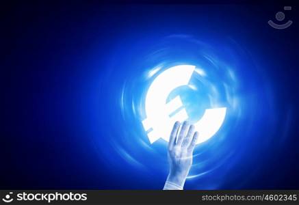 Euro currency. Close up of human hand holding euro symbol on blue background