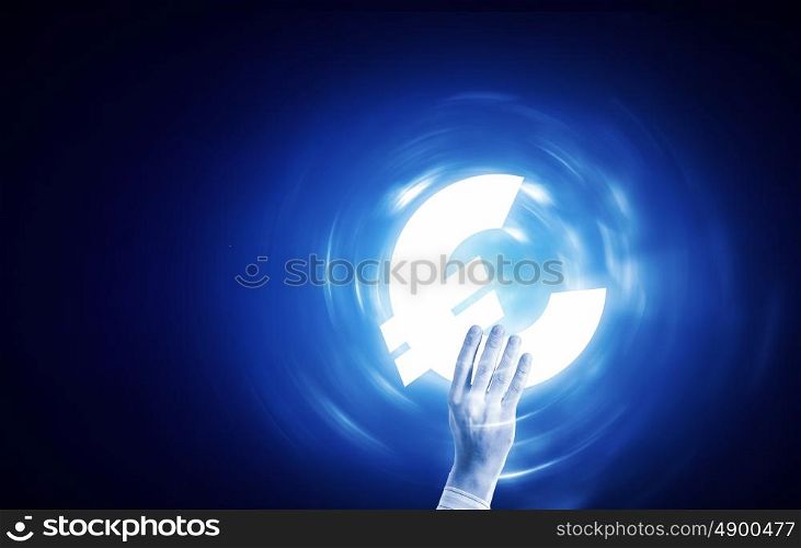Euro currency. Close up of human hand holding euro symbol on blue background