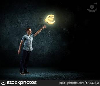 Euro currency concept. Young man and euro sign against dark background