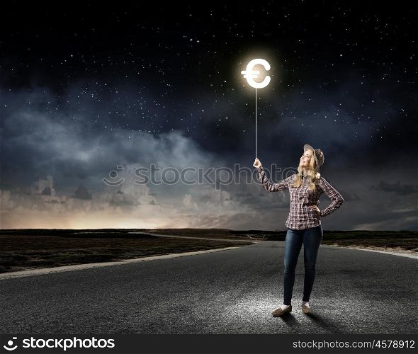 Euro currency. Young woman holding balloon shaped like euro sign