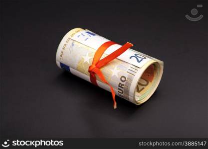 euro money in a red ribbon on black