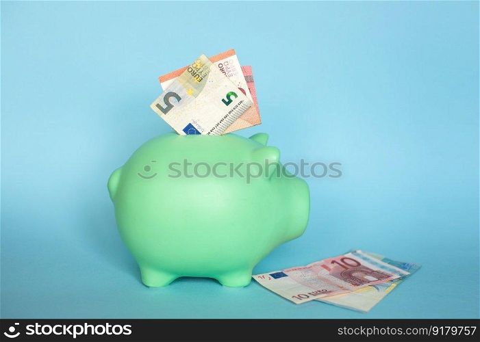 Euro notes. blue piggy bank with 10 and 5 euro notes