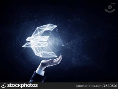 Euro symbol in palm. Hand of businessman holding euro glowing sign on dark background