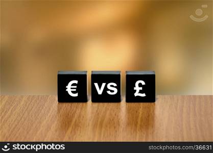 euro versus pound currency on black block with blurred background