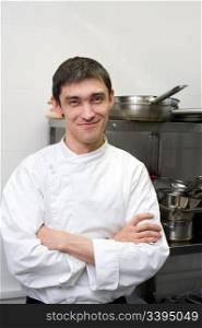 european chef with crossed arms looks smiling into camera