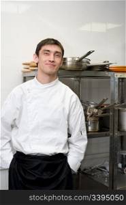 european chef with his hands in pockets looks into camera