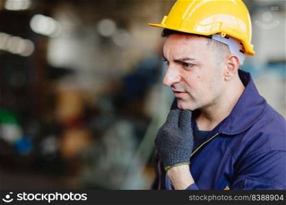 European Russian worker thinking handsome factory man wearing helmet safety suit and hand groove.
