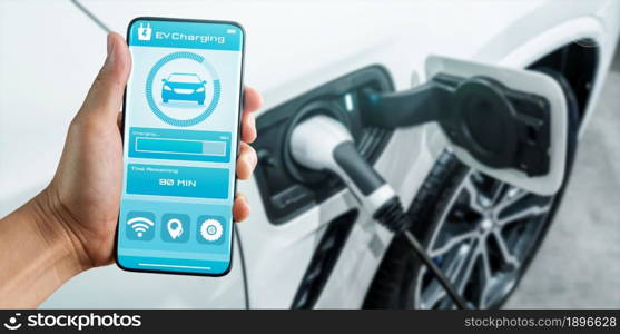 EV charging station for electric car with mobile app display charger status . The electric power is produced from sustainable resources to supply to charger station in order to reduce CO2 emission .. EV charging station for electric car with mobile app display charger status