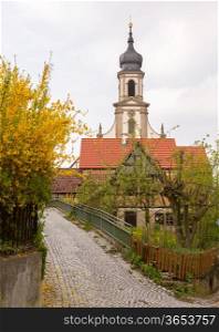 Evangelical Lutheran church of St Johannis or Johannes in small Bavarian village of Castell in Germany. Church rises above trees from surrounding vineyards of Castell winery.