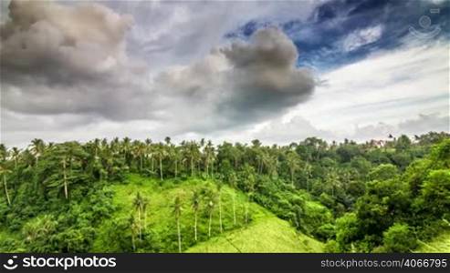 Evening clouds over green hill in tropics time lapse