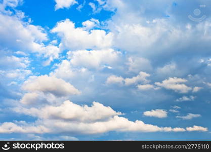 evening cumulus clouds in blue summer sky