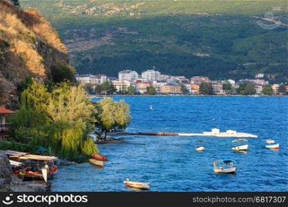 Evening lake with boats and Ohrid town summer top view (Macedonia). People are unrecognizable.