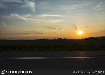 Evening landscape. Sunset in a field in the clouds