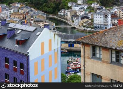 Evening Luarca cityscape (top view) with colorful boats in fishing port, Asturias, Spain.