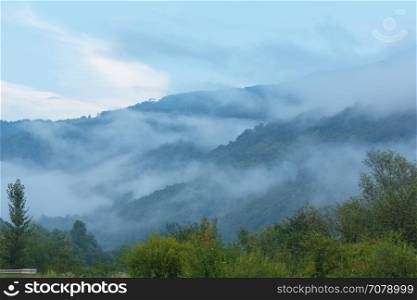 Evening mist over slope of summer mountain (Carpathians, Lviv Oblast, Ukraine).