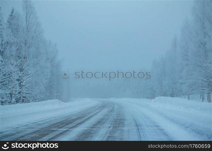 Evening northern forest. Empty highway. Lots of snow and fog. Empty Winter Highway in the Forest