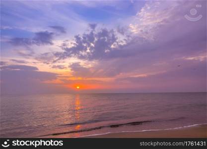 Evening on the beach of a calm endless sea. Multicolor sunset and clouds. Multicolor Sunset over Calm Sea