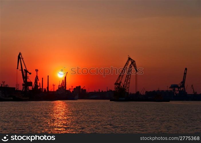 Evening sea port, cargo cranes against the setting sun. Odessa. Ukraine.