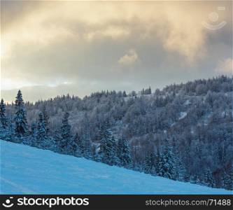 Evening sky with yellow clouds over winter Ukrainian Carpathian Mountains. Two shots stitch image.