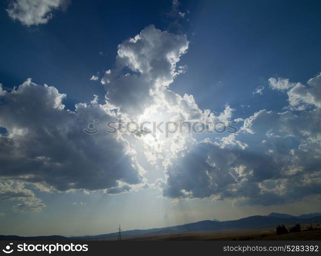 Evening summer landscape with green grass, road and clouds