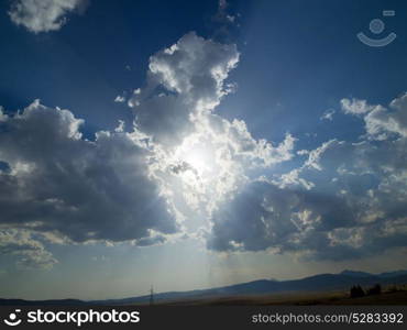 Evening summer landscape with green grass, road and clouds