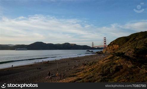 Evening time lapse of people leaving the beach by the Golden Gate Bridge