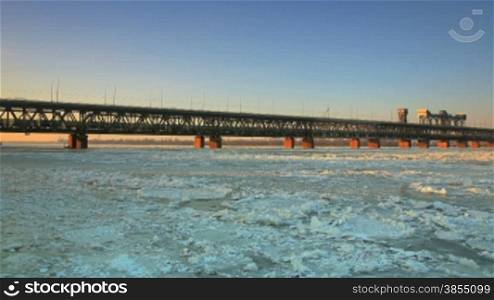 Evening time lapse. railway bridge with ice floes.