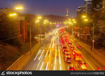 Evening traffic, illuminated city prospect, Motherland monument in background, Kiev, Ukraine