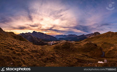 Evening twilight autumn alpine Dolomites mountain scene, Trento, Italy. View from Lake or Laghetto Baita Segantini. Picturesque traveling, seasonal, nature and countryside beauty concept scene.