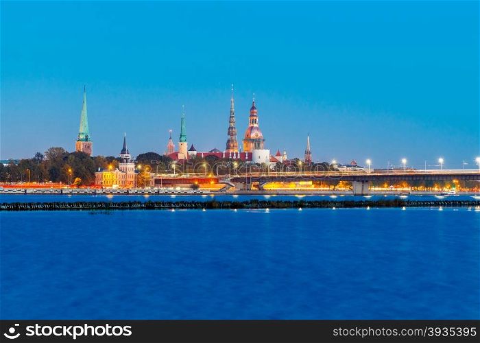 Evening view on the embankment of the Daugava River and the spiers of churches in Riga.. View Riga at sunset.