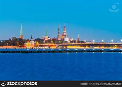 Evening view on the embankment of the Daugava River and the spiers of churches in Riga.. View Riga at sunset.