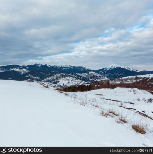 Evening winter cloudy day snow covered alp Gorgany mountain ridge (Ukraine, Carpathian Mountains, Homiak, Syniak and other mounts, scenery view from Yablunytsia pass).