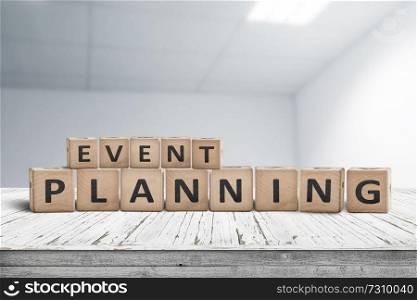 Event planning sign on a wooden desk in an office with a blurry grey background