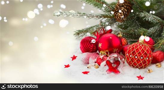 evergreen tree and red christmas decorations on white snow, banner with copy space. evergreen tree and red christmas decorations