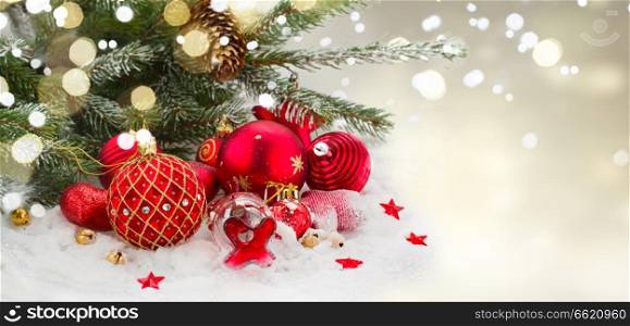 evergreen tree and red christmas decorations on white snow , winter banner. evergreen tree and red christmas decorations