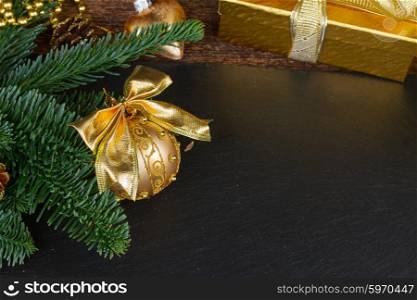 evergreen tree with golden decorations . evergreen fir tree with golden ball and gift box christmas frame on black background