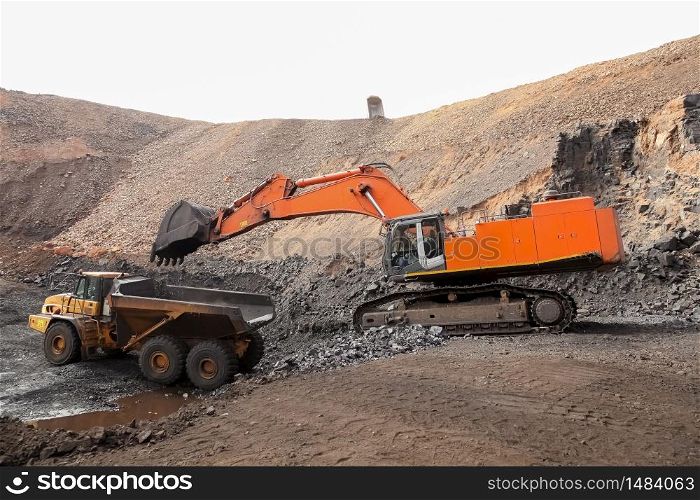 Excavator digging and loading ore rocks on a Manganese mine
