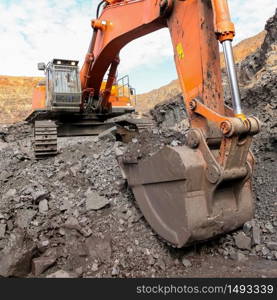 Excavator digging and loading ore rocks on a Manganese mine