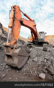 Excavator digging and loading ore rocks on a Manganese mine