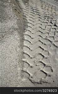 excavator tyres footprint on quarry white sand pattern