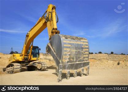 excavator yellow vehicle sand quarry outdoor blue sky