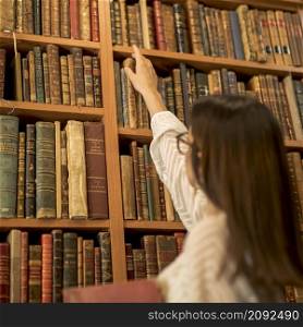 excellent female student choosing vintage book library