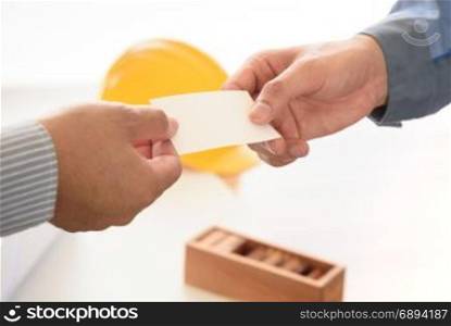 exchanging business card with engineering tools background, selective focus