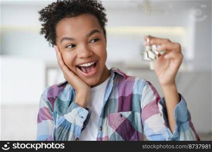 Excited african american teen girl tenant showing keys of first new house. Happy biracial female delighted with renting apartment holds home key. Relocation, real estate rental service.. Excited african american teen girl tenant showing keys of first new house. Real estate rent service
