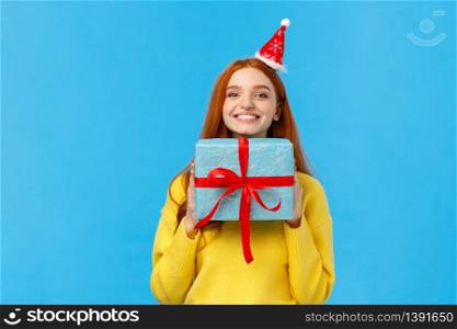 Excited and happy cute redhead girlfriend enjoy celebrating christmas, secret santa event as receive lots gifts, holding present, bragging with blue wrapped new year gift, smiling joyfully.. Excited and happy cute redhead girlfriend enjoy celebrating christmas, secret santa event as receive lots gifts, holding present, bragging with blue wrapped new year gift, smiling joyfully