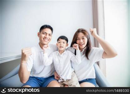 Excited and Happy family with arms raised while watching television at home